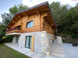 a log house with a balcony on top of it at Chalet 7 Luxury Chalet with Cinema room in Crans-Montana