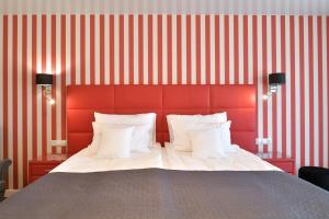 a bedroom with a large bed with a red headboard at TI Hotel in Rogaška Slatina
