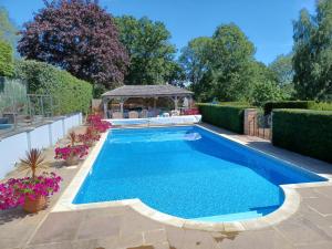 a swimming pool with a gazebo in a yard at Rookwood Farmhouse B&B in Newbury