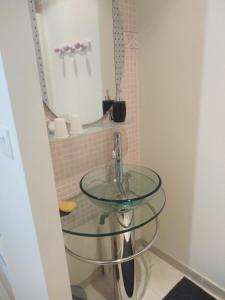 a bathroom with a glass sink and a mirror at Chambre agréable au calme in Saint-Hilaire-Petitville