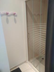 La salle de bains est pourvue d'une cabine de douche avec une porte en verre. dans l'établissement Chambre agréable au calme, à Saint-Hilaire-Petitville