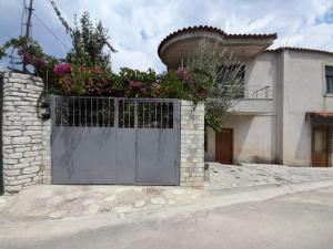 a gate in front of a house with flowers at Mona's guesthouse in Sarandë