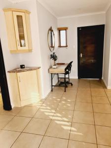 a kitchen with a table and a desk in a room at Finna's lovely 1-bedroom open plan vacation home. in Germiston