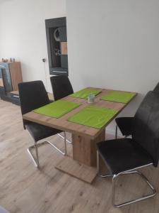 a wooden table with four chairs and a green placemark at Appartement Georg in Sankt Englmar