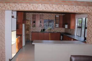 uma cozinha com armários de madeira e uma bancada em Global Guest House em Kasane