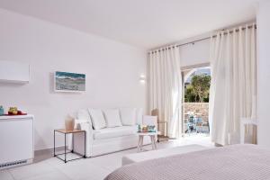 a living room filled with furniture and a window at Santo Miramare Beach Resort in Perivolos