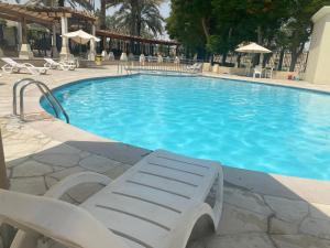 una piscina con panchina bianca di fronte di Spacious 4-bedroom villa, children friendly a Dubai
