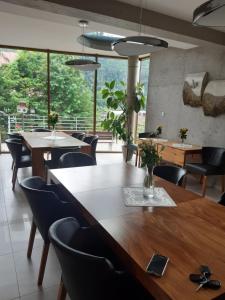 a dining room with tables and chairs and a large window at Jaśminowe Ogrody in Szczyrk