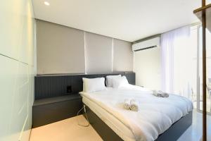 1 dormitorio con 1 cama grande y zapatillas. en Modern Studio Apt w Balcony in Heart of Tel Aviv by Sea N' Rent, en Tel Aviv