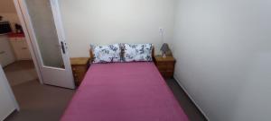 Habitación con cama con alfombra rosa en TAVARI HOUSE, en Tavari