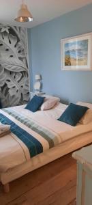 een slaapkamer met een groot bed met blauwe kussens bij Bâtisse XVIII ème, dans enceinte d'un château. in Brains-sur-Gée
