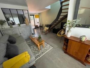 ein Wohnzimmer mit einer Couch und einer Treppe in der Unterkunft Maison Candau in Pessac + 4 Fotos