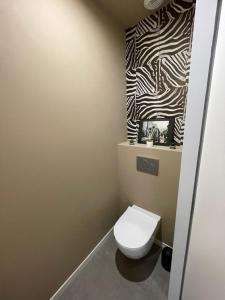 ein Bad mit einem WC und einer Zebra-Wand in der Unterkunft Maison Candau in Pessac