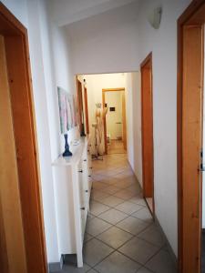 a hallway with white walls and a white tile floor at Apartman Dane in Duće