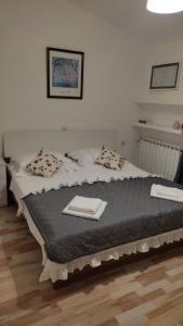 a bedroom with a bed with two towels on it at Apartman Dane in Duće