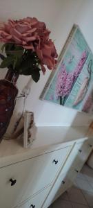 a table with a vase of flowers and a picture at Apartman Dane in Duće