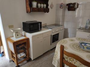 uma pequena cozinha com um micro-ondas e um fogão em MC em Gonnesa