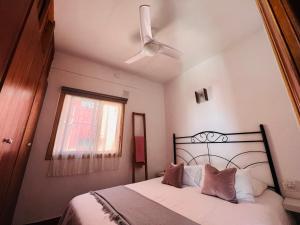 1 dormitorio con 1 cama, ventilador de techo y ventana en Maravillosas vistas al mar "Primera Línea" Apartamentos Can Toca - Seahouses, en Santa Cruz de Tenerife