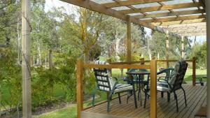 eine Veranda mit Stühlen und einem Tisch auf einer Terrasse in der Unterkunft Camawald Coonawarra Cottage B&B in Coonawarra