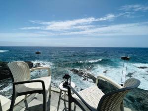 a view of the ocean from a balcony with chairs at Maravillosas vistas al mar "Primera Línea" Apartamentos Can Toca - Seahouses in Santa Cruz de Tenerife