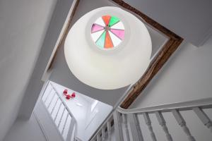 an attic room with a circular window and stairs at Utopian Hotel, a charming guesthouse in Porto