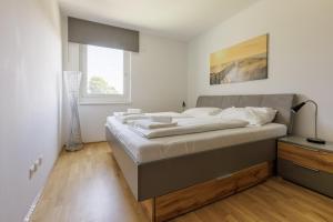 a large bed in a room with a window at Vienna City and SPA - Modern Apartments next to Therme Wien & 15 Minutes to the City Center in Vienna