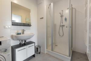 a bathroom with a sink and a shower at Vienna City and SPA - Modern Apartments next to Therme Wien & 15 Minutes to the City Center in Vienna