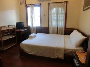 una camera con letto, finestra e televisore di Hoxieng Guesthouse 1 a Luang Prabang