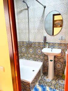 uma casa de banho com um lavatório, uma banheira e um espelho. em Rahmat guesthouse em Bukhara