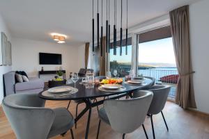 een eetkamer met een tafel en stoelen en een woonkamer bij Premium apartment with beautiful sea view, short walk to the sea in Opatija
