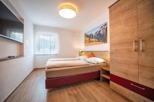 sypialnia z łóżkiem i dużą drewnianą szafką w obiekcie Apartments Cesa Ploner w mieście Ortisei