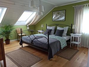 a green bedroom with a bed and a couch at by VOLLMER´s komfortabel und chic in Offenburg