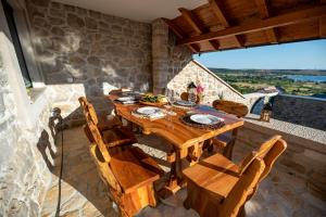 uma sala de jantar com uma mesa de madeira e cadeiras em Didov dvor em Ražanac