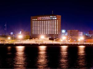 a large building with lights in a city at night at Kushiro Prince Hotel in Kushiro