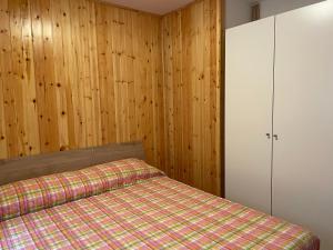 皮恩卡瓦羅的住宿－La Casa di Pianca，一间卧室设有一张床和木墙