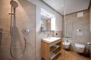 a bathroom with a shower and a sink and a toilet at Apartments Cesa Ploner in Ortisei