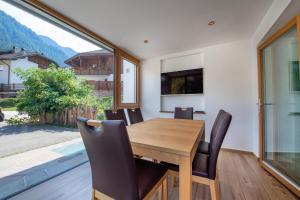 a dining room with a wooden table and chairs at Apartments Cesa Ploner in Ortisei