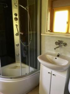 uma casa de banho com um chuveiro e um lavatório. em Domki w Rowach em Rowy
