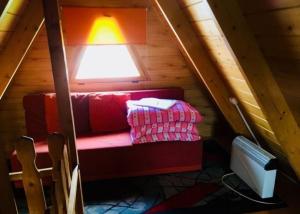 a room with a red couch in a attic at Domki w Rowach in Rowy