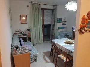 een woonkamer met een bank en een tafel bij Casa vacanza Colle Renazzo con terrazzo in collina 15 min. dal mare in Mafalda