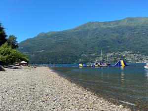 a beach with a rocky shore with mountains in the background at Casa Vittoria in Dervio