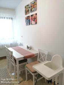 een witte eettafel met stoelen en een wastafel bij Cozy Apartment Narciselor Suceava in Ipoteşti