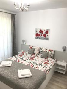 a bedroom with a large bed with two towels on it at NEW Aparthotel Floresti in Floreşti