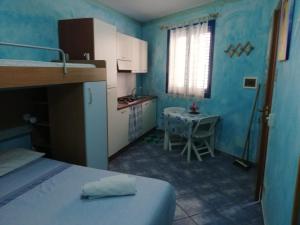 a small blue room with a bed and a table at Il Gabbiano blu - Monolocale Blu in Marettimo