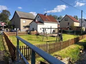 um parque infantil num quintal com uma cerca de madeira em SaidenbachHaus em Großhartmannsdorf