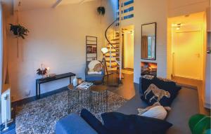 a living room with a blue couch and a fireplace at 3 Bedroom Nice Home In Heinkenszand in Heinkensand