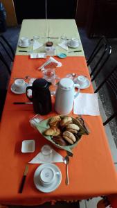 una mesa naranja con un plato de comida. en Pasos Andinos B&B en Eugenio Bustos