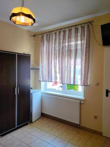 een keuken met een raam, een wastafel en een vaatwasser bij Pokoje Gościnne u Piotra in Ustronie Morskie