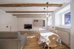 sala de estar con mesa y sofá en Dolomites Apartments Cesa Benedet, en Santa Cristina Valgardena