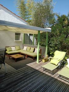 un patio con sofá y sillas en una terraza en l'allerie studio en Les Sables-dʼOlonne